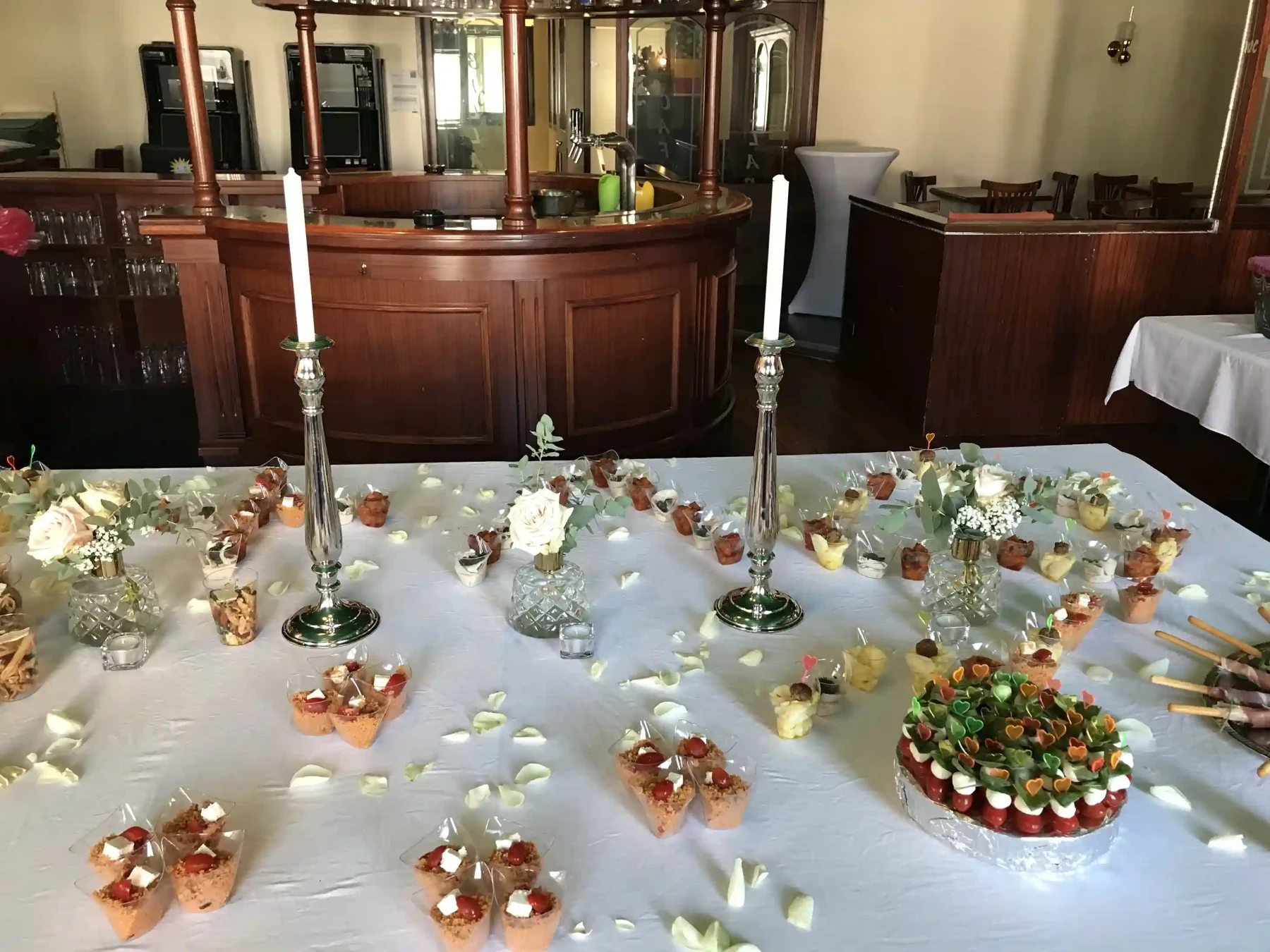 Fingerfood-Buffet mit Kerzen und Blumen vor der Restaurantbar